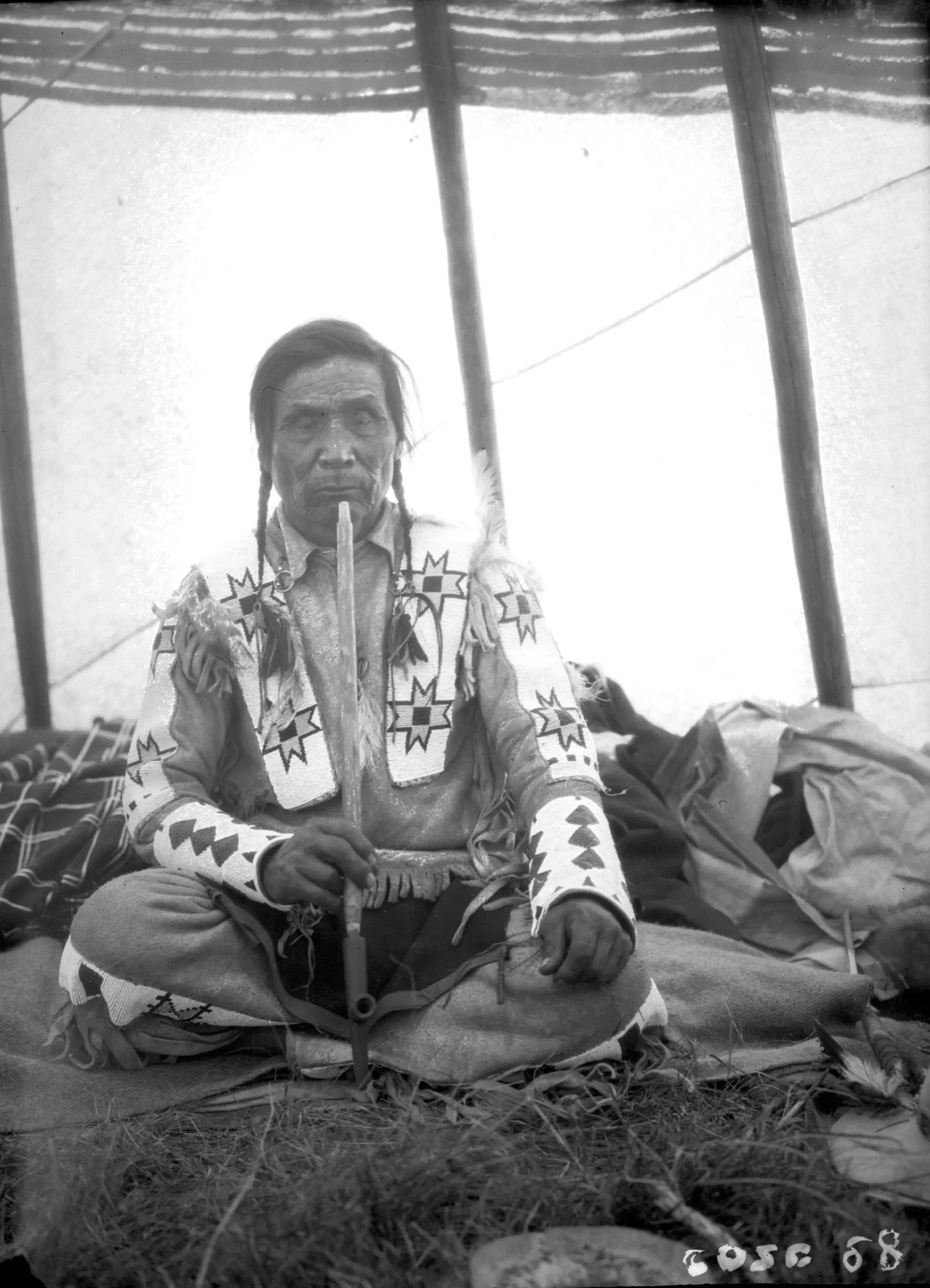 Squatipew of the Star Blanket Band seated in a tent with a pipe