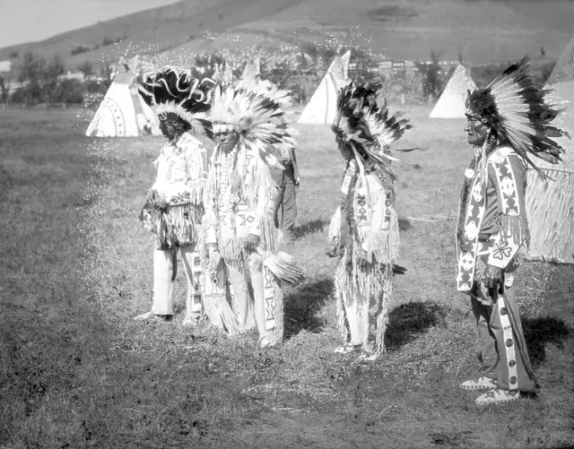 Plains Cree men in regalia at a powwow camp